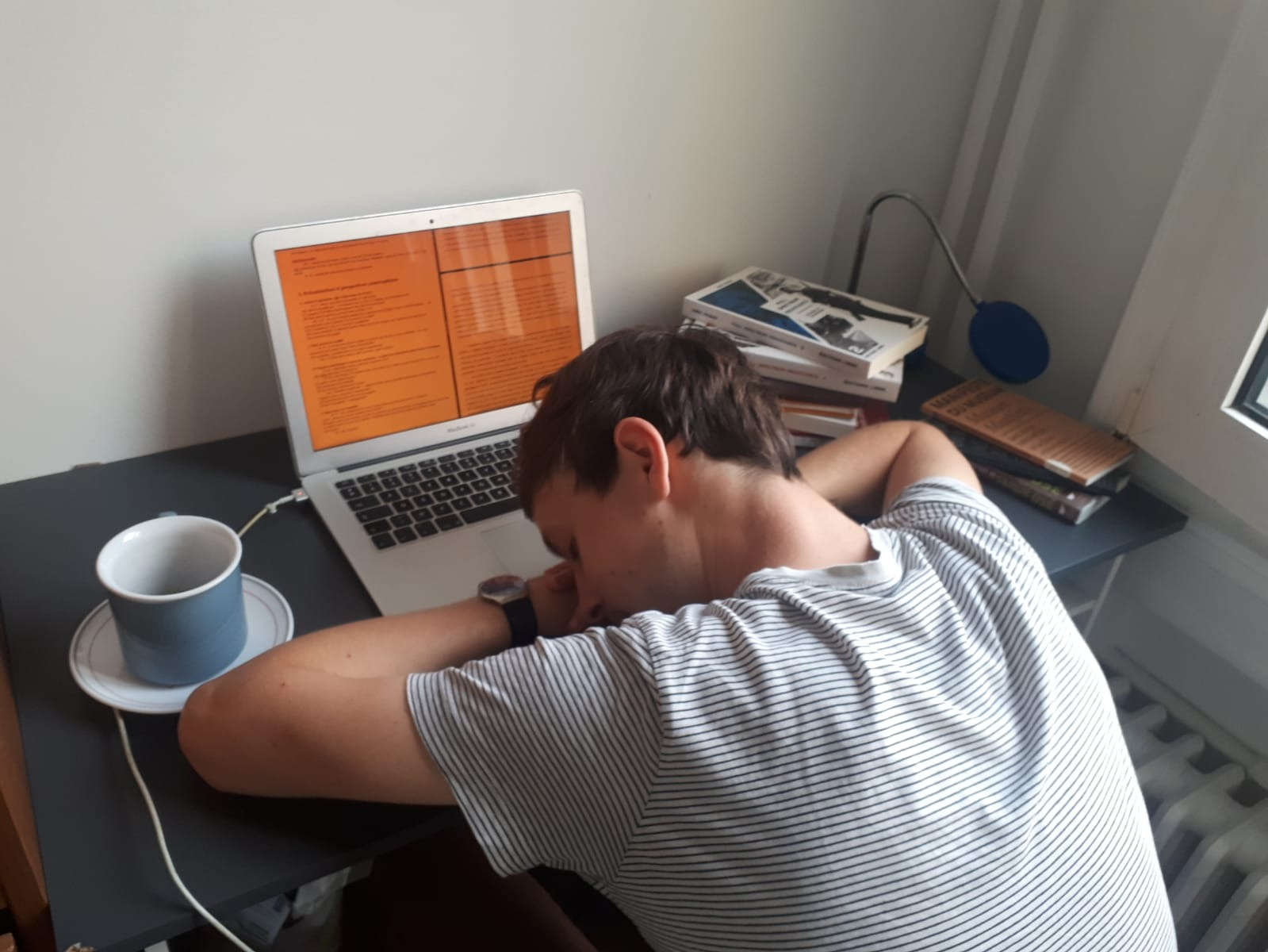 Student sleeping on laptop at desk