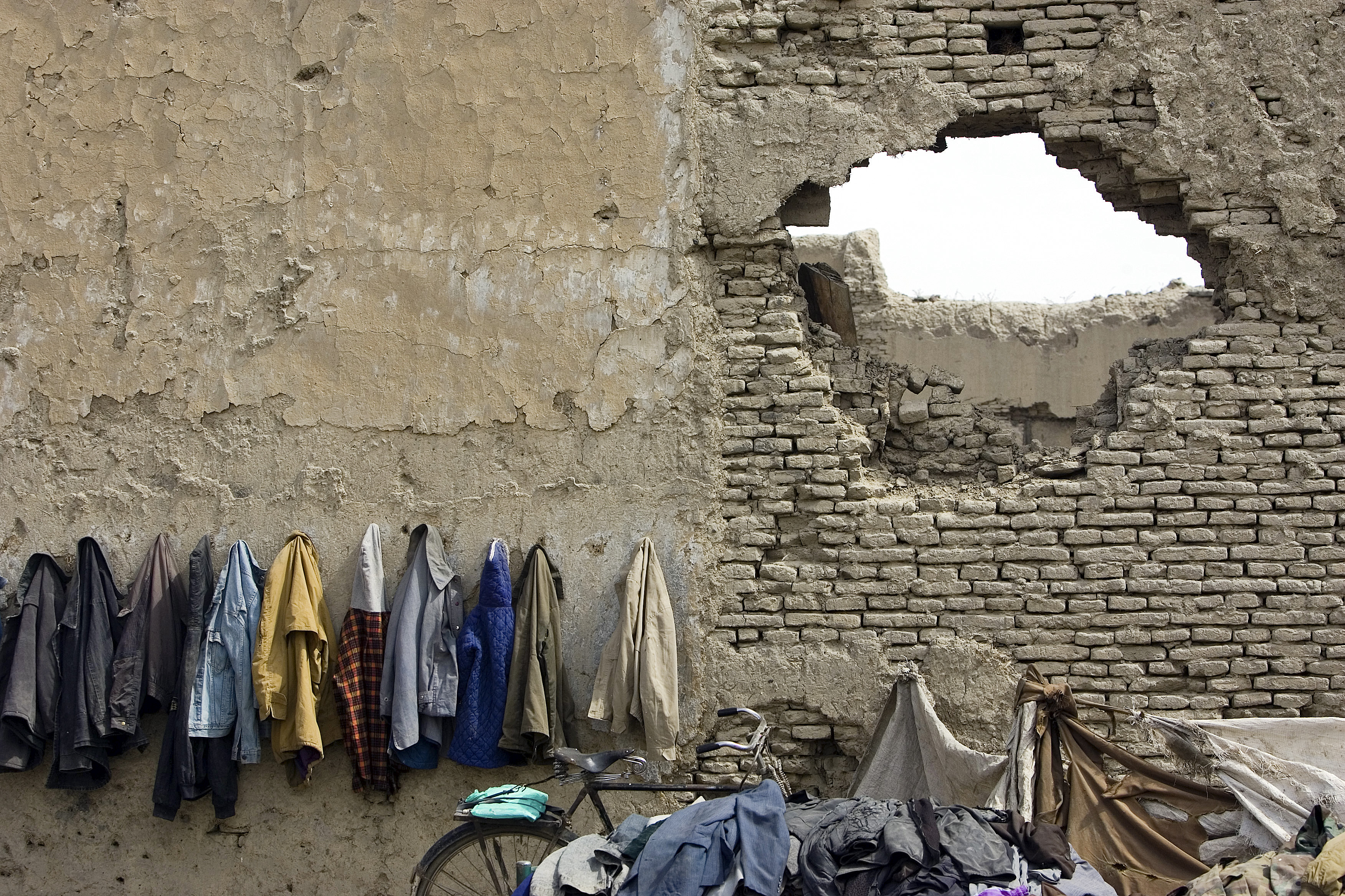 Afghan students' coats hanged on the wall destroyed by the war, Kabul, Afghanistan 